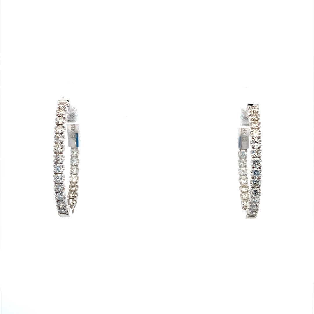A pair of 14 karat white gold oval hoops set with diamonds