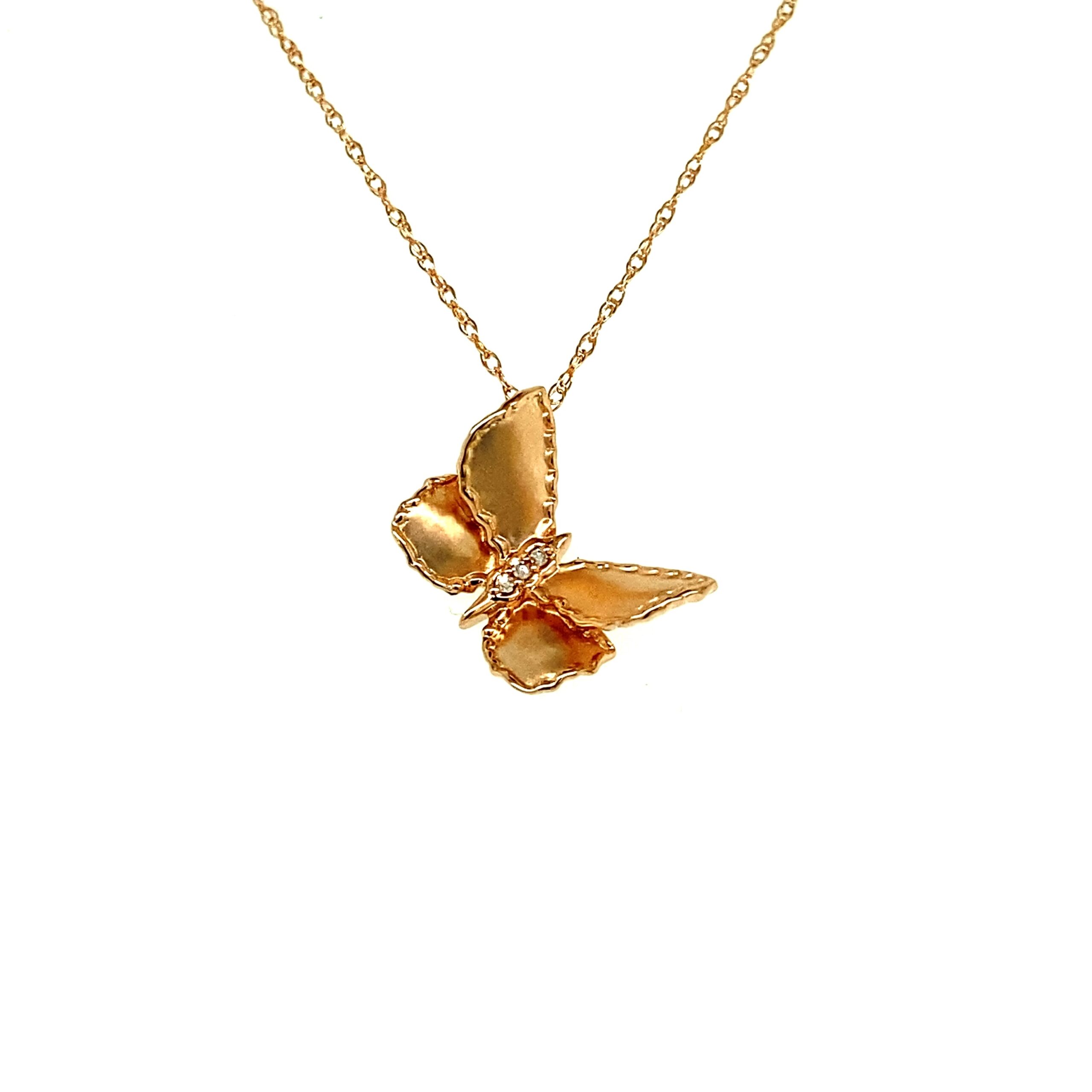 A rose gold diamond butterfly pendant necklace set with 3 round diamonds