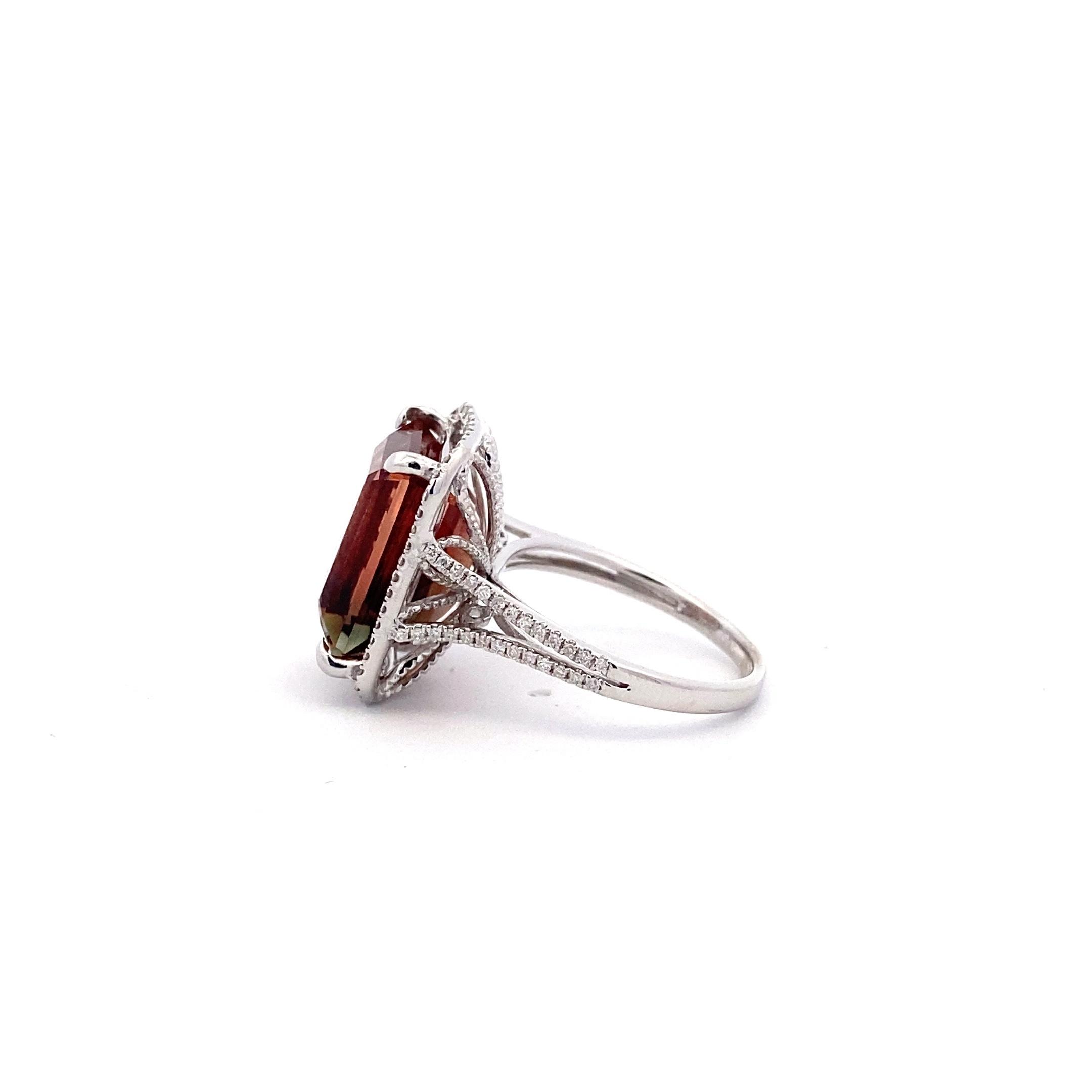 One estate 14 karat white gold ring with a center emerald-cut sunstone accented by 98 diamonds in the halo and the split-shank shoulders of the band