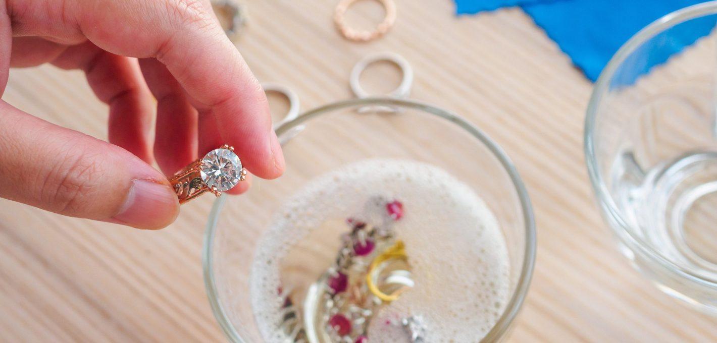 Jeweller hand cleaning vintage jewelry diamond ring closeup