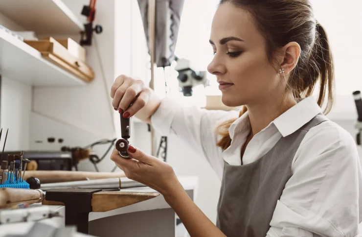Expert jewelry services, a bench jeweler uses tools to expertly repair jewelry