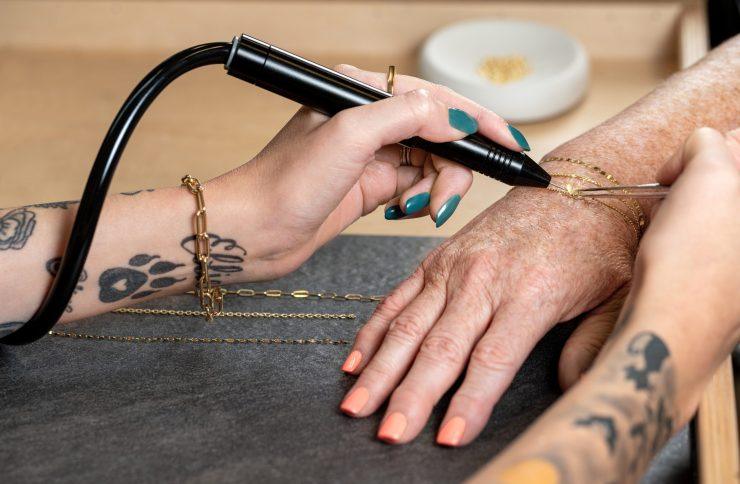 A woman getting a permanent jewelry bracelet