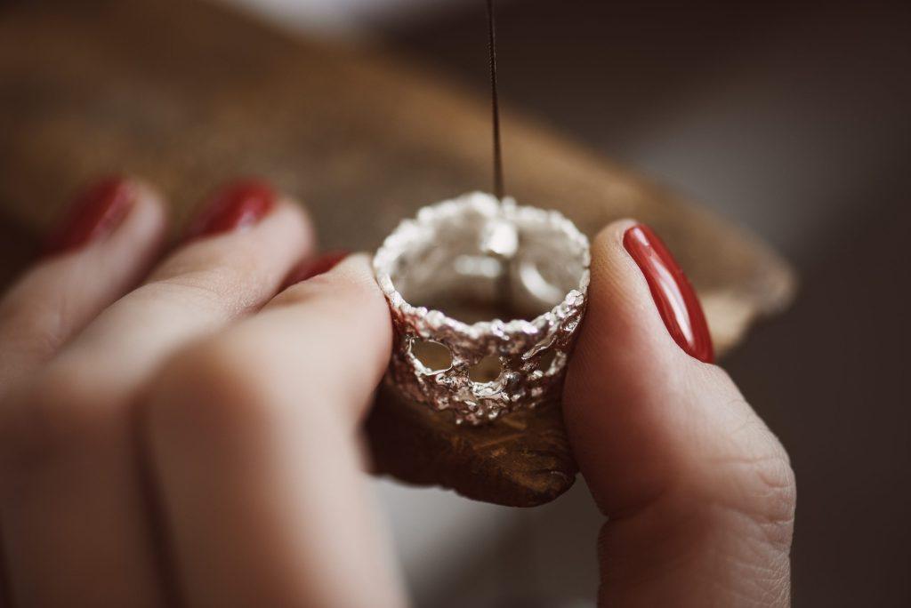 A close-up of a woman's hands repairing a ring