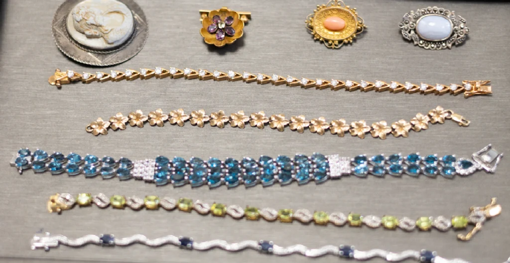Various pieces of gold, silver, and platinum jewelry neatly sorted on a tray ready for review