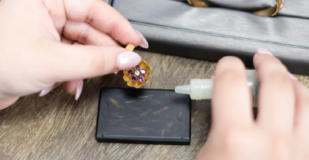 Buyer performing an acid test on a gold jewelry piece to determine metal purity