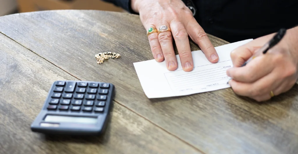 Buyers writing a purchase offer after evaluating jewelry items