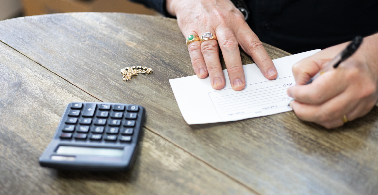 Buyers writing a purchase offer after evaluating jewelry items