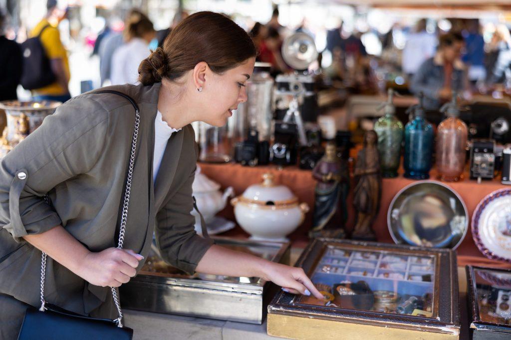 A woman shopping for vintage jewelry at an antique market