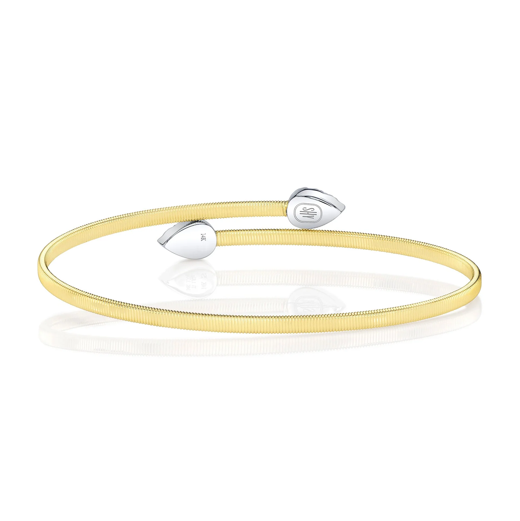 A two-tone gold bypass cuff bracelet containing round-faceted diamonds weighing 0.44 carat total weight in pear-shaped finials